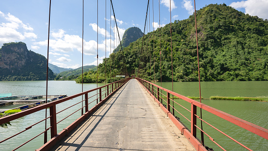 Suspension bridge over a river and fish farming in northern Vietnam