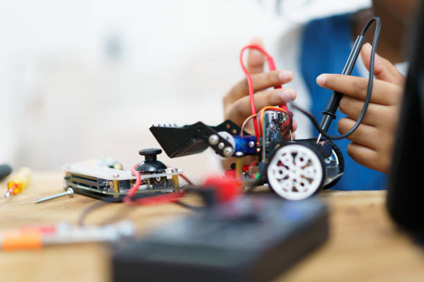 une petite fille assemble un jouet robot. - computer lab child internet development photos et images de collection