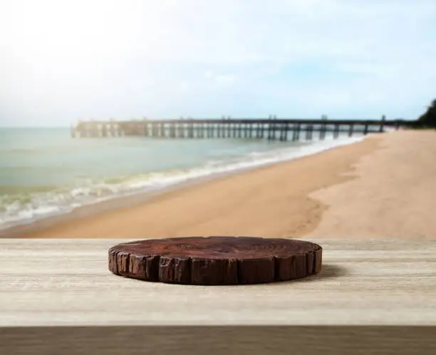 Wooden cuttingboard on wooden table for standing product against sea landscape