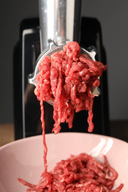istock Electric meat grinder with beef mince on table, closeup 1831757040