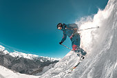 Freeride skier jumps at off-piste ski slope