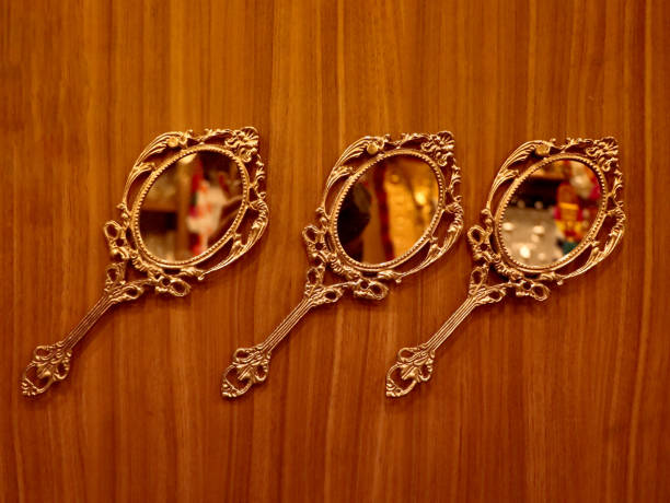 three vintage round golden hand mirrors