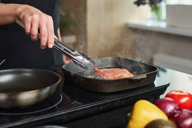 istock Man Putting Chili Pepper Next to Frying Steak 1831804801