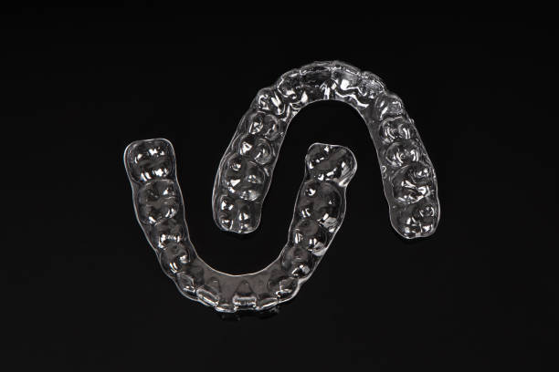 istock Invisible orthodontics cosmetic brackets on black background. Tooth aligners, for beautiful smile. 1831815915