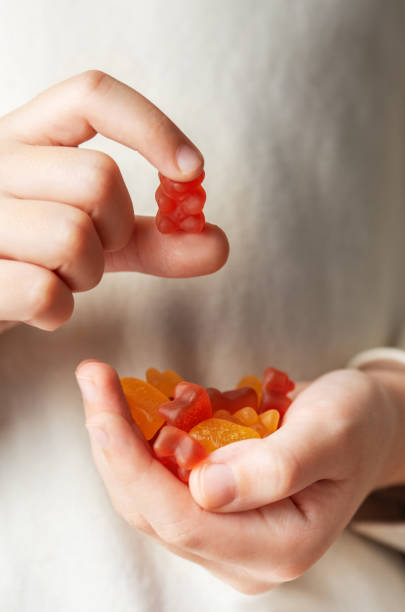 istock A girl holds a gummy bear vitamines in her hands 1831831121