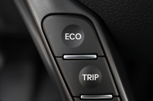 ECO mode button and Trip button in a modern car, with copy space. Fuel conservation concept.