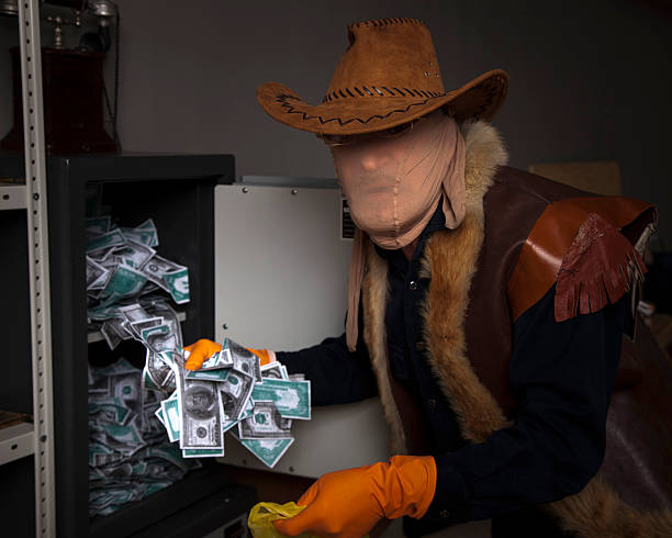 istock thief steals money from the safe 183186371