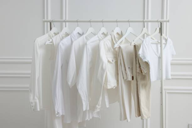 istock Rack with different stylish women`s clothes near white wall indoors 1831863875