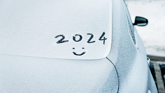 New year 2024 and smiling face written on car windshield