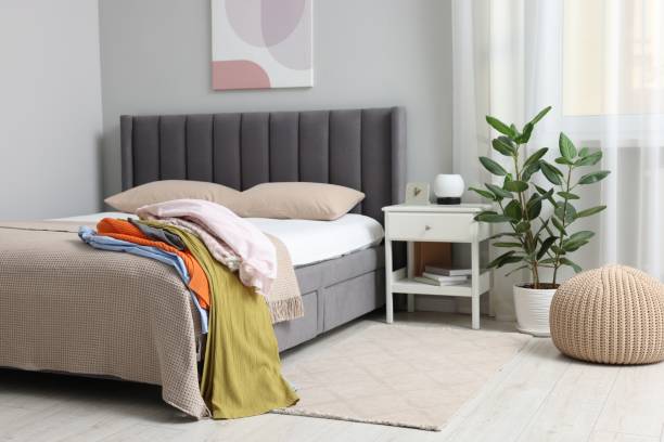 istock Pile of different clothes on bed indoors 1831864406
