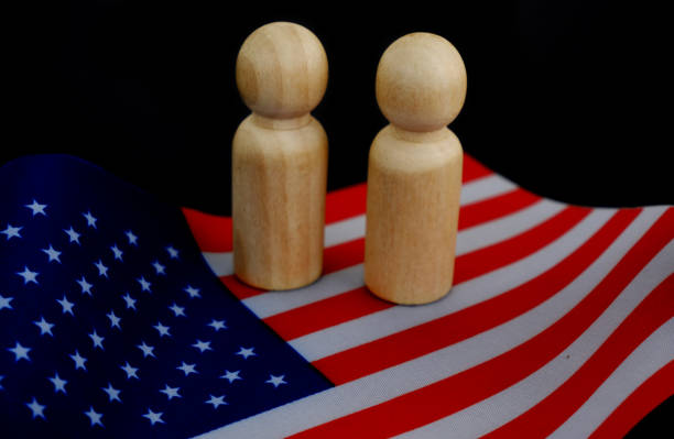 istock Two people figures as candidates on US national flag on black background. 1831865991