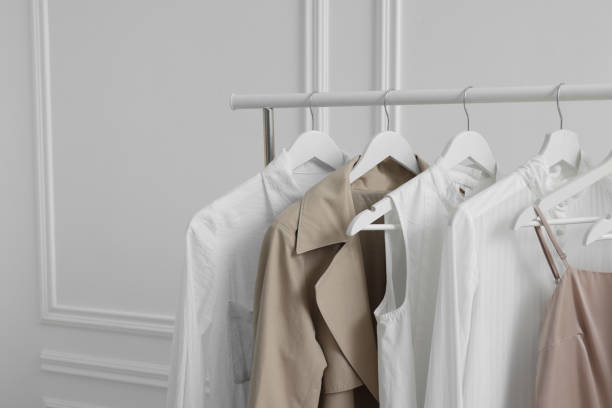 istock Rack with different stylish women`s clothes near white wall indoors, space for text 1831866497