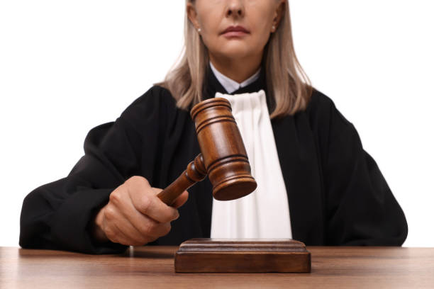 istock Judge with gavel at wooden table on white background, closeup 1831875763