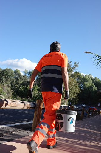 Barcelona, Spain, 28 Oct 2023 - Worker in hi-vis gear on roadwork duty, symbolizing job safety and infrastructure care