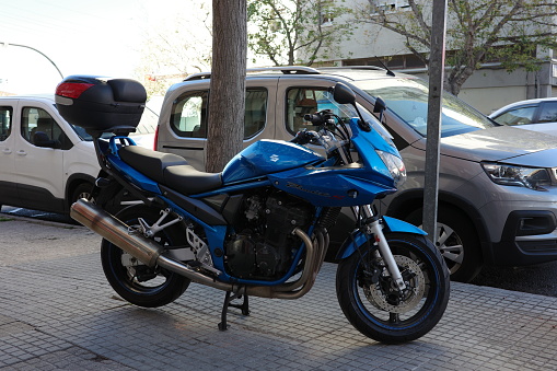 Barcelona, Spain, 28 Oct 2023 - Parked blue motorbike on a city sidewalk, amidst evolving urban regulations enhancing pedestrian mobility and safety