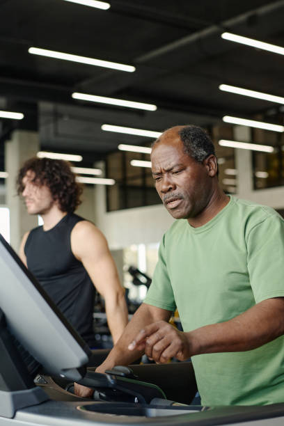 istock Elderly Man Looking at Treadmill Monitor with Doubt 1831943718