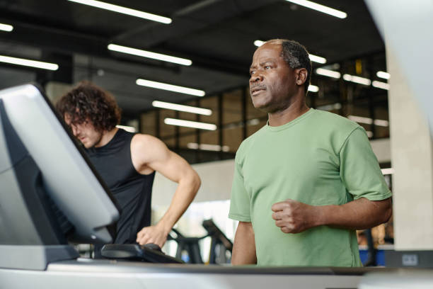 istock Senior Man Looking into Distance Standing on Treadmill 1831943990