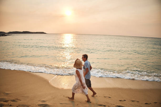 istock Senior couple enjoying walking along the beach 1831998647