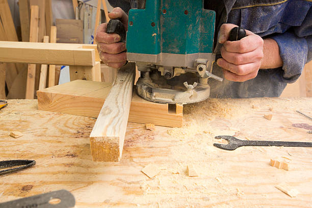 istock man using router on plank of wood 183202465