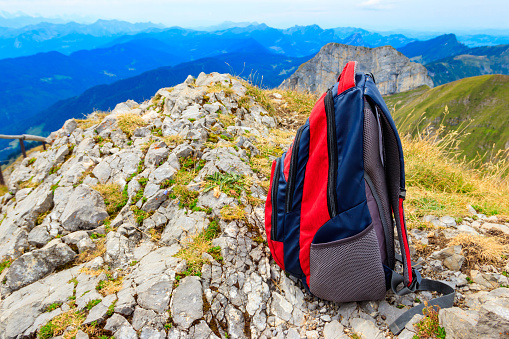 Tourist backpack on background of mountains in Swiss Alps. Travel outdoor concept