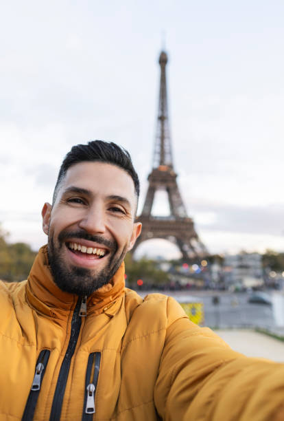 istock happy latin man taking a selfie in paris with the eiffel tower in the background 1832053880