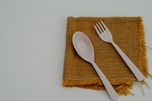 plastic spoon and fork on burlap