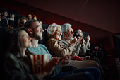 Happy senior couple applauding after a movie in cinema.