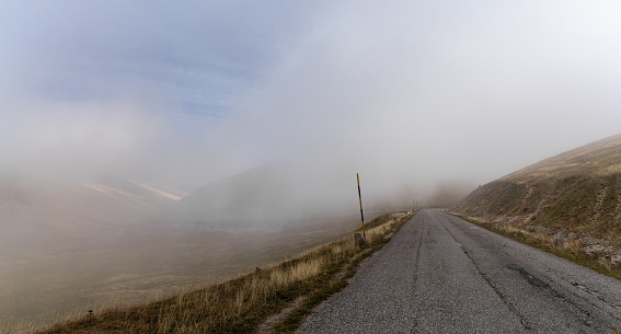 mountain road leading into thick fog in the Gran Sasso and Monti della Laga National Park in Abruzzo