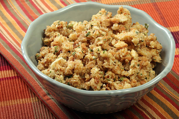 White decorative bowl of stuffing on a striped tablecloth Part of Thanksgiving dinner stuffing. Stuffing stock pictures, royalty-free photos & images