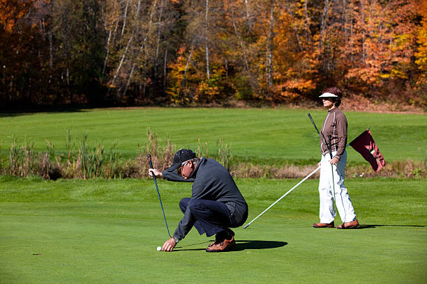 sênior casal em ação os jogadores de golfe no campo de golfe - senior couple golf retirement action - fotografias e filmes do acervo