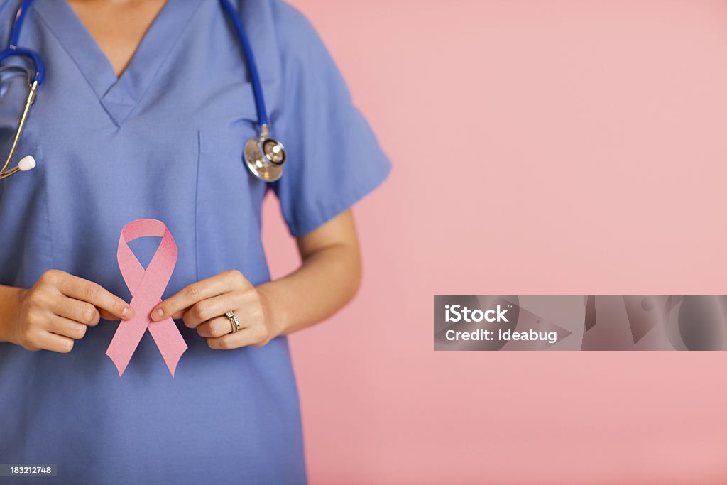 Infirmière en tenant le ruban de sensibilisation pour le Cancer du sein rose - Photo de Cancer du sein libre de droits