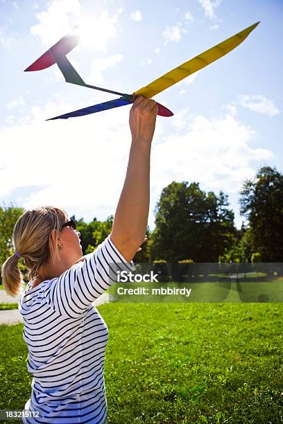 Foto de Mulher Segurando De Madeira Modelo De Avião e mais fotos de stock de Avião - Avião, Brinquedo, Colorido