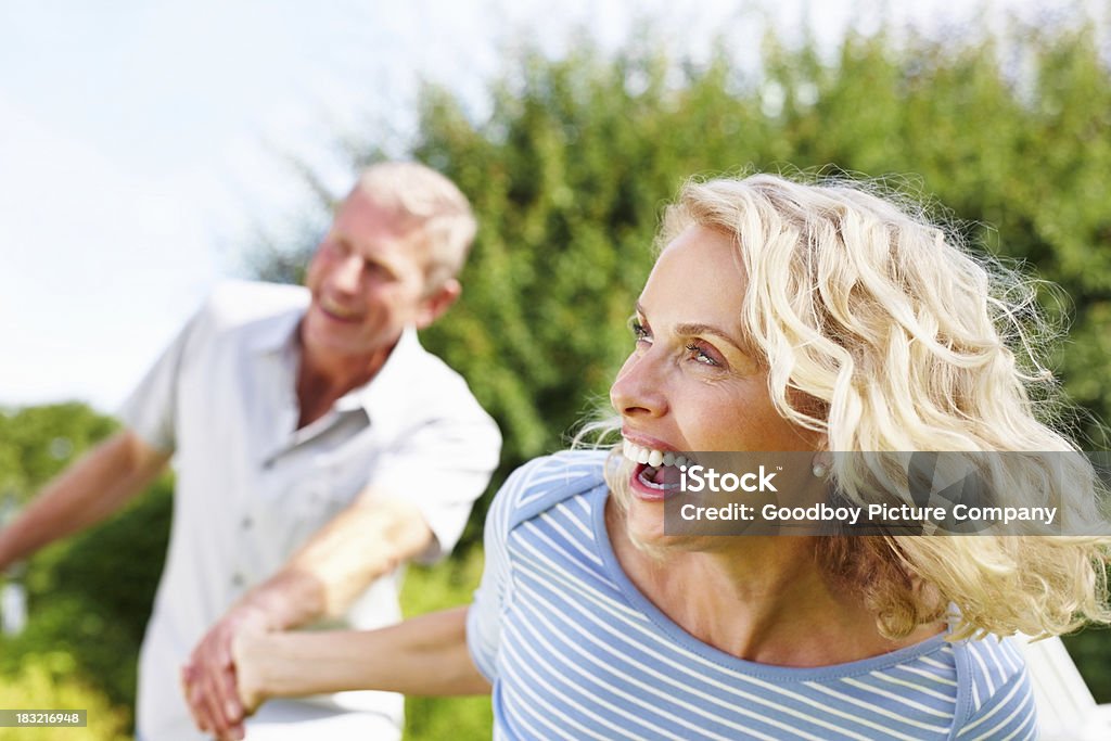 Rire, mature femme tenant la main d'un homme senior - Photo de Quadragénaire libre de droits