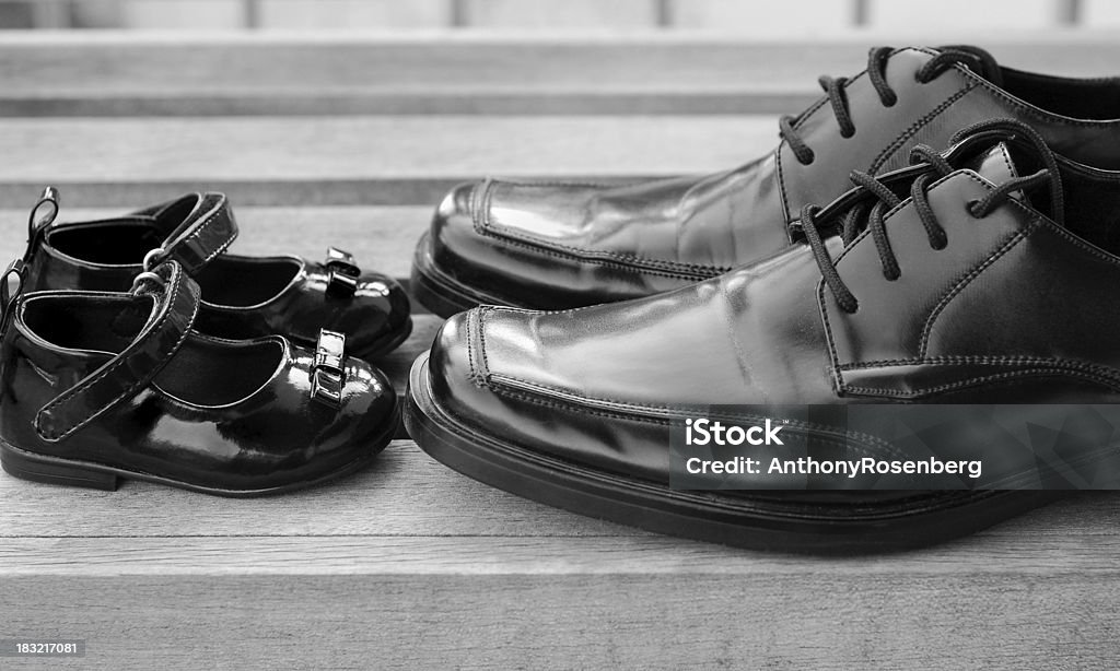 Father's Day Close up of a father's black dress shoes touching his young daughter's black dress shoes in black and white.  See also Shoe Stock Photo