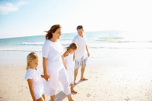 istock Happy couple with their daughter walking on beach 183218020