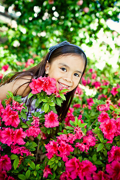 istock cute girl smiling behind flower bush 183218264