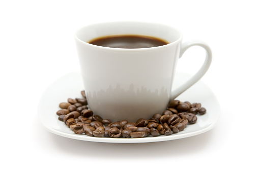 Cup of black coffee. Coffee beans on saucer. White background.