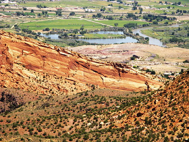 Colorado National Monument  Fruita "View from Colorado National Monument overlooking the town of Fruita.The cliffs are made of Entrada/Wingate/Kayenta sandstone layers in various shades of red and white The establishment of the national monument in 1911 was largely due several years of campaigning by one man, John Otto, who explored the canyons and single-handedly built many miles of trails through the area. Rocks are red when they contain the mineral hematite, which is an iron oxide that is similar to rust." fruita colorado stock pictures, royalty-free photos & images