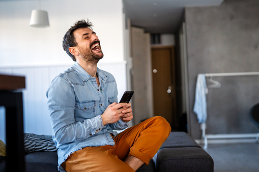 Young man using cellphone for work, social media or relaxation. Smart phone people concept.