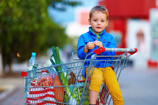 kid in trolley after shopping