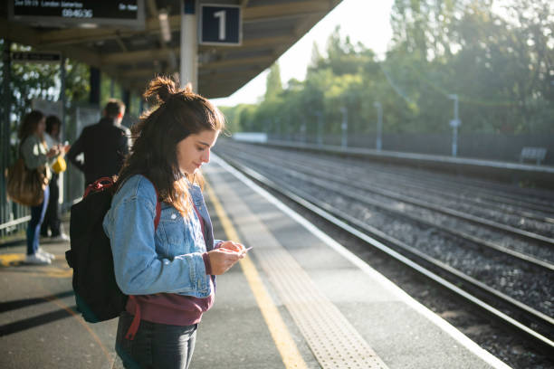 Young woman standing at the train station while train arriving.