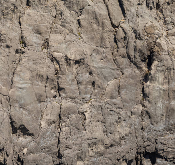 istock Weathered seaside rock face texture. Aged volcanic stone wall surface. 1832257406