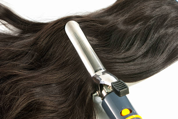 istock Electric curling iron and hair on white background 183225940