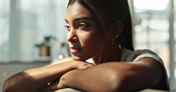 istock Thinking, idea and young woman on a sofa relaxing with a memory or reflection in living room. Brainstorming, planning and Indian female person with doubt chilling in the lounge of modern apartment. 1832280458