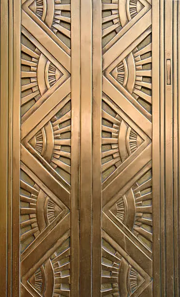 Detail of an Art Deco style bronze door taken in New York City. The design features alternating triangular patterns with rays expanding outward from the point of each triangle suggesting sun rays. (See similar in the "Art Deco Style" light box.)