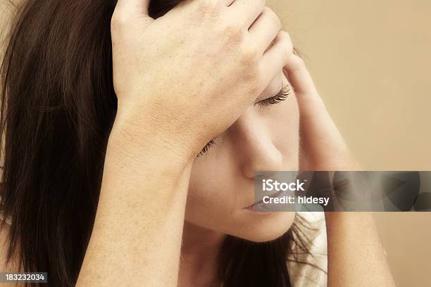 Woman Suffering From A Migraine On Tan Background Stock Photo - Download Image Now - 20-24 Years, 20-29 Years, 25-29 Years