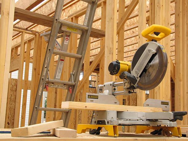istock Yellow Miter Saw and Lumber Against Framed Construction Background 183232131