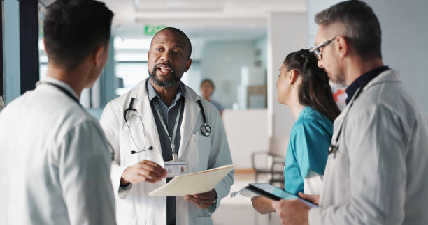 istock Doctors, nurses and team or hospital management with workflow, schedule planning and speaking of services. Healthcare worker, mentor and people with medical documents, clinic files and internship 1832324467