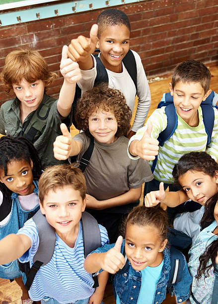 gruppo di felice elementare studenti mostrando il pollice in alto - child school children elementary student group of people foto e immagini stock