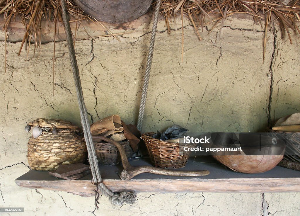 Antigua ollas y cestas contra una pared de ladrillo - Foto de stock de Agrietado libre de derechos